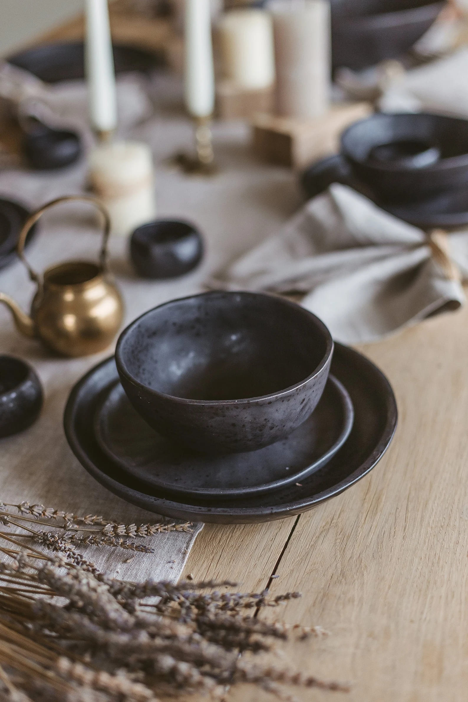 Handcrafted dark ceramic tableware on a wooden table