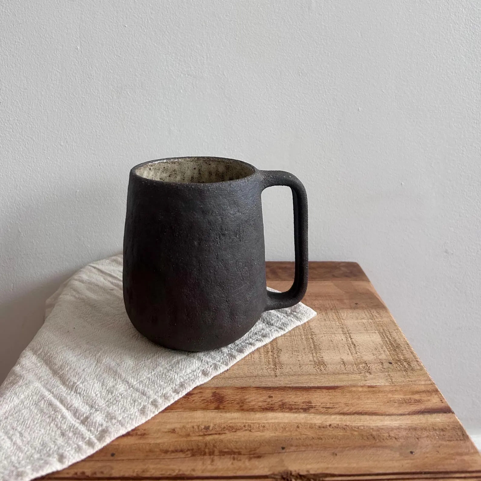 Set of four textured dark ceramic cups stacked